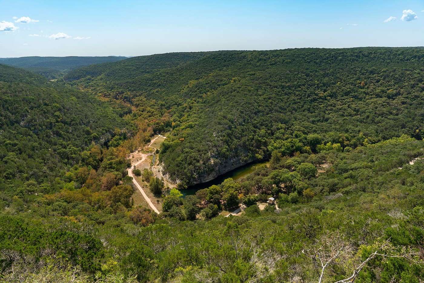 Lost Maples day-use area as seen from East Trail which follows the clif side. Photo taken in early fall but change in foliage color of eponymous maples is alrea
